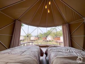 坤西育府Eco Eyes Village的帐篷内的两张床,设有大窗户