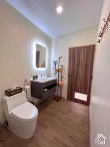 坤西育府Eco Eyes Village的一间带卫生间、水槽和镜子的浴室