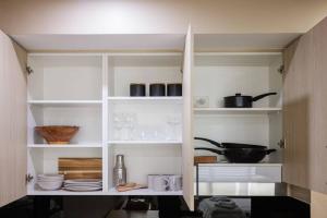 悉尼NEW! Ideal 1BR Unit in the Hot Spot of Surry Hills的一间厨房,配有白色的书架,餐具和器 ⁇ 