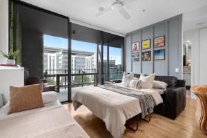 布里斯班Brisbane Luxury Gabba Apartment的一间带两张床和一张沙发的卧室
