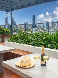 布里斯班Brisbane Luxury Gabba Apartment的一张桌子,上面放着一瓶葡萄酒和两杯酒