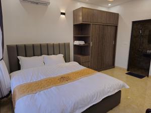 Làng Trang4L HOTEL KIM BÔI的一间卧室配有一张大床和一个木制橱柜