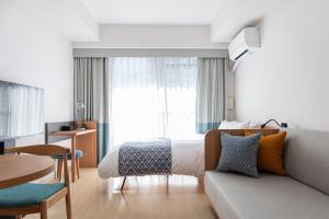 大阪yksi STAY ＆ APARTMENT OSAKA的酒店客房,配有床和沙发