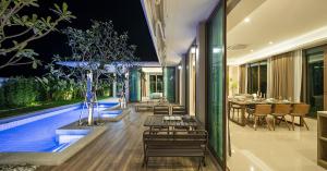 华欣Relaxing Luxury 3-Bed Private Villa的一个带桌椅的户外用餐区和一个游泳池