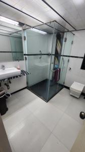 孟买Home sweet home 3BHK的一间带玻璃淋浴和水槽的浴室