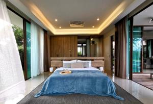 华欣Relaxing Luxury 3-Bed Private Villa的一间卧室配有一张带蓝色毯子的大床