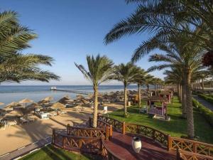 赫尔格达Hawaii hotels & blend club resort&sea jul&的享有棕榈树和遮阳伞海滩的景致。