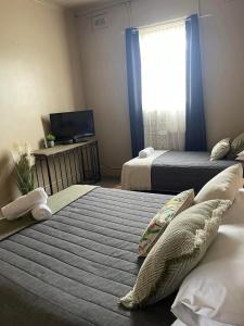 QuirindiFederal Hotel的一间卧室设有两张床、一台电视和一扇窗户。