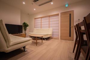 小樽Ryoan / Vacation STAY 80251的客厅配有椅子、电视和桌子
