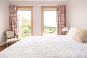 RelbiaRural Apartment with Stunning Views的卧室配有一张白色大床和一把椅子