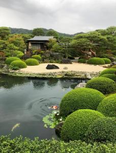 东京吉吉の家的花园中的池塘,后面有房子