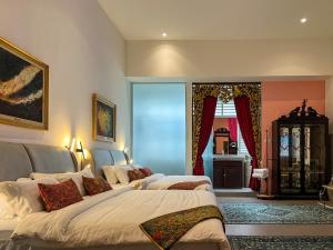 乔治市Peranakan Suites Georgetown的一间卧室设有两张床和窗户。