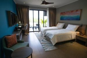 博瓦隆Thalassa Seychelles的酒店客房,配有两张床和椅子