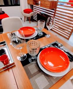 圣保罗Hotel MRC PINHEIROS- The Best Excellence Duplex Studio Pinheiros - Red Velvet Deluxe Edition - First Class - By LuXXoR的一张桌子上放着红盘和酒杯