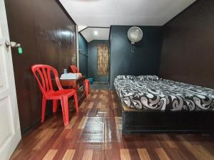 珍拉丁Maznah Guest House的卧室配有1张床、1张桌子和1把椅子