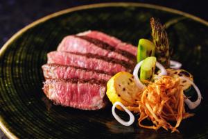 OyamaFuji Speedway Hotel - The Unbound Collection by Hyatt的上面有肉和蔬菜的绿色盘子