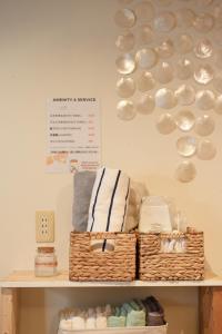 神户Hostel Ini kobe & Donut cafe的墙上的带毛巾和篮子的架子