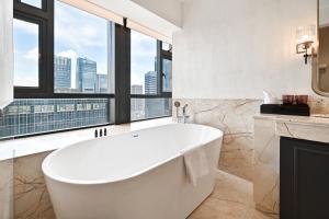 广州广州番禺总统大酒店的带浴缸的浴室和大窗户