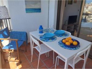 莫特里尔Chic Home Tropical beach Motril with garage的一张白色的桌子,上面放有盘子和橘子碗