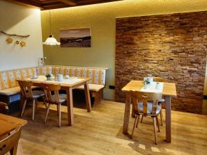 沙伊代格贝格布里克酒店的餐厅设有木桌和椅子,拥有砖墙