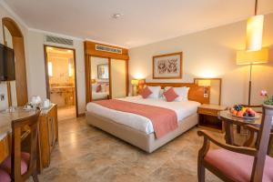 卢克索Jolie Ville Hotel & Spa Kings Island Luxor的酒店客房设有一张大床和一张书桌。