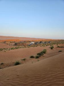 BadīyahDesert Heart Camp的远处的沙漠和营地的景色