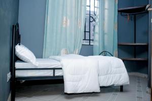 达累斯萨拉姆Swahili Homes- Ada Estate的一间卧室配有一张带白色床单的床和一扇窗户。
