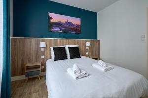 讷韦尔Le Faidherbe style Appart' Hôtel - WIFI gratuit - Parking Gratuit Calme et Lumineux的卧室配有一张带两个枕头的大白色床