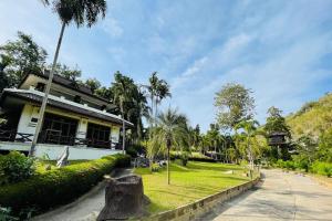 北碧Baan Rim Kwai Paerimnam Resort的前面有树桩的房子
