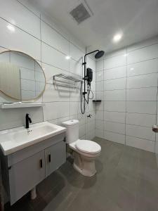 仙本那Halo Hotel的一间带卫生间、水槽和镜子的浴室