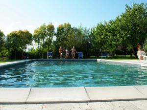 阿夏诺Chic Farmhouse in Asciano Italy with Swimming Pool的一群人站在游泳池周围