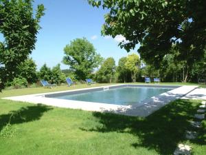 阿夏诺Chic Farmhouse in Asciano Italy with Swimming Pool的公园内的游泳池,带两把蓝色椅子