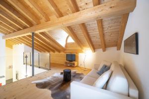 施库尔Chasa Capricornin的客厅设有白色沙发和木制天花板。