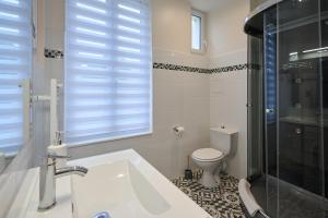 讷韦尔Le Faidherbe style Appart' Hôtel - WIFI gratuit - Parking Gratuit Calme et Lumineux的一间带水槽和卫生间的浴室以及窗户。