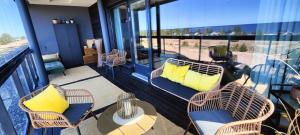 卡拉约基Timantti Apartments by Hiekka Booking的阳台配有藤椅和带黄色枕头的桌子。
