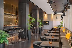 阿姆斯特丹art'otel amsterdam, Powered by Radisson Hotels的一间设有桌椅的餐厅,种植了植物
