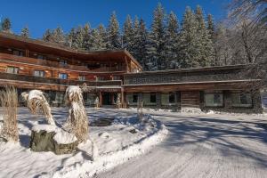 切拉德纳Horský hotel Lorkova vila的建筑物前的雪地小屋