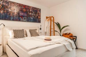 科佩尔Koper Seaside Residence的卧室配有白色的床和帽子