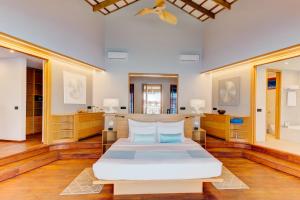 Felidhoo Cinnamon Velifushi Maldives的卧室配有一张白色的大床,铺有木地板