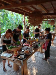 艾湄湾阿迪别墅酒店的一群人站在桌子旁吃着食物