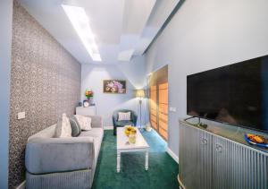 布加勒斯特Phoenicia Comfort Hotel的带沙发和平面电视的客厅