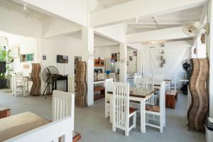 ZambalesCostas De Liwa Bar & Beach Resort的一间配备有白色椅子和桌子的用餐室