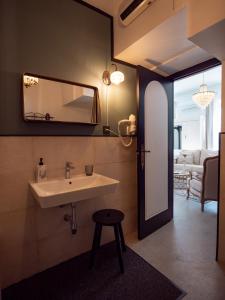 Pinos del ValleFinca Casabela的一间带水槽、镜子和凳子的浴室