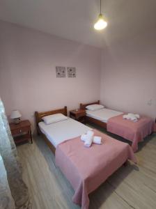 尼弗拉斯纳Vrasna Luxury Apartment的配有粉红色床单的客房内的两张床