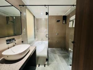 艾哈迈达巴德Hotel Mivaante的浴室配有水槽、淋浴和浴缸。