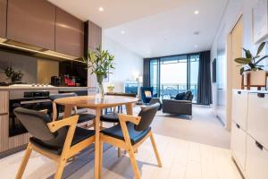 悉尼Contemporary 2-Bed Apartment Minutes to City的厨房以及带桌椅的用餐室。