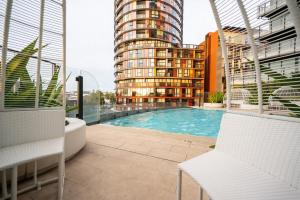 悉尼Contemporary 2-Bed Apartment Minutes to City的一个带游泳池和大楼的阳台