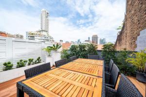 悉尼Sublime Locale with Skyline Views from Courtyard的屋顶庭院的木桌和椅子