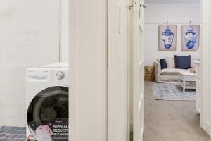 悉尼Art Deco Apartment Meters Away From The Beach的客厅配有洗衣机和沙发。