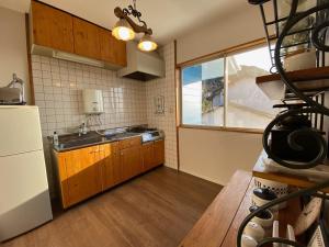 北九州H&H - Vacation STAY 14242的厨房配有水槽、冰箱和窗户。